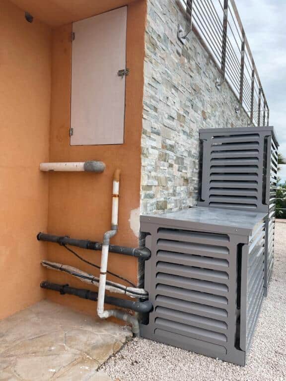 Deux caches clim cote a cote sur facade en pierre